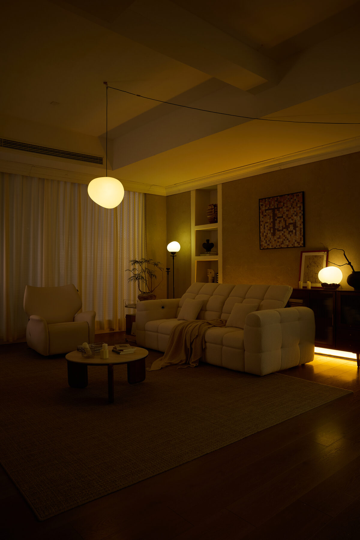 A sofa glowing under ambient lighting dimmed to a movie-night setting.