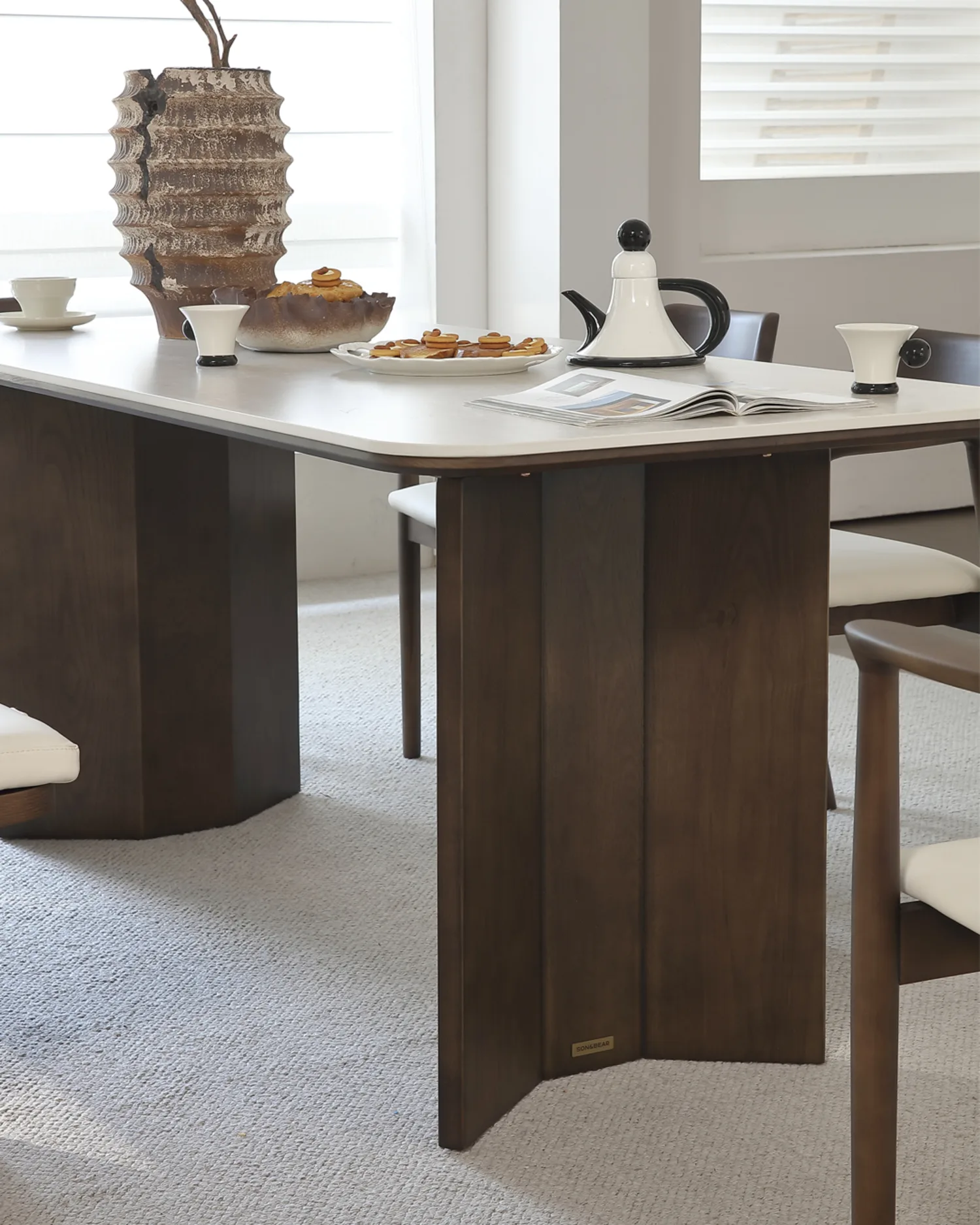 Rumi rectangular dining table seen from the side, showing the folded panel plinth